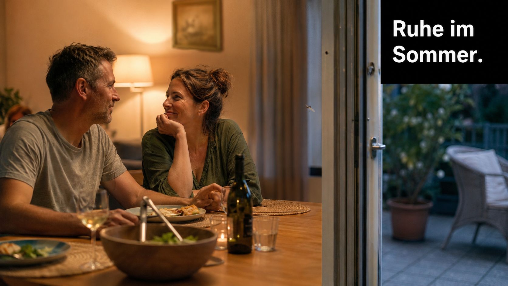 Ein glückliches Paar genießt ein Abendessen zu Hause bei entspannter Stimmung und sommerlicher Atmosphäre im Wohnzimmer.